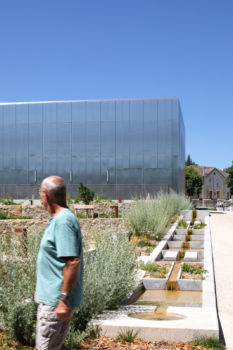 Basalt | Musée | Paladru Homme regardant le cube métallique devant les fontaines