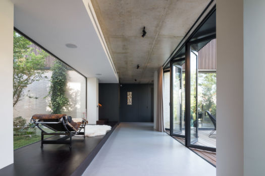 Basalt | Maison | Paris Intérieur moderne avec baies coulissantes, béton et estrade en bois. Mobilier design