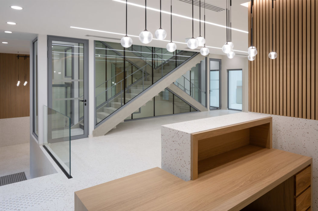 SHA | Accueil | Paris Borne d'accueil, escalier, paroi en bois et luminaire boule