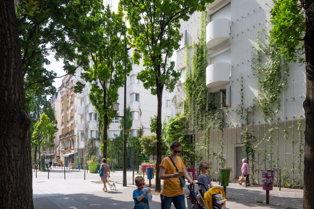 Frédéric Bernard Architecture | Réhabilitations de Logements | Paris Famille marchant dans la rue avec la végétation grimpante en arrière-plan